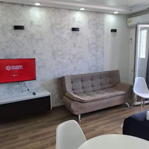 a living room with a couch and a flat screen tv at BATUMi SEA TOWERS SEA VIEW 15 G in Angisa