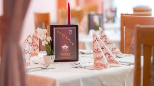 a table with a clock and flowers on it at Strandhotel Orchidee in Sankt Kanzian