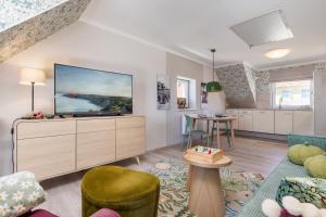 a living room with a flat screen tv on a dresser at Ferienwohnung Morgen am Meer in Sassnitz