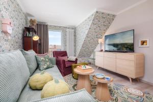 a living room with a couch and a tv at Ferienwohnung Morgen am Meer in Sassnitz