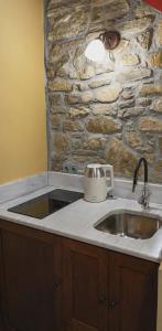 a kitchen with a sink and a stone wall at Thetis Stone Residence in Volissos +38 photos
