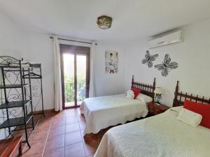 a bedroom with two beds and a window at Casa Jardin Alhambra in Granada