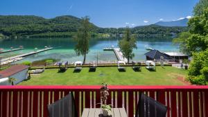a balcony with a view of a dock on a lake at Strandhotel Orchidee in Sankt Kanzian