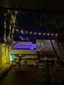 a patio with tables and chairs at night with lights at Panama Experience Hostal in Panama City