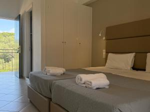 two beds with towels on them in a bedroom at Anemona Studios in Paleokastritsa +36 photos