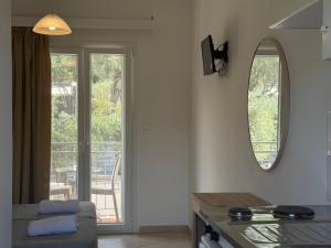a living room with a table and a mirror at Anemona Studios in Paleokastritsa