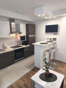 a kitchen with white and black appliances and a table at Apartman Škribulja in Županja +14 photos