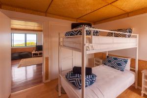 a bedroom with two bunk beds in a room at White Waves on the Beach in Hastings Point