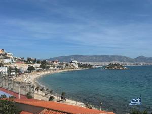 Blick auf einen Strand mit Gebäuden und dem Meer in der Unterkunft Agatha-4 in Piräus