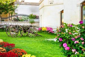 a garden with flowers in front of a building at Empire Cave Cappadocia in Göreme +58 photos