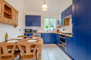 a blue kitchen with a wooden table and blue cabinets at 2 Bed in Laxton oc-p44858 in Laxton