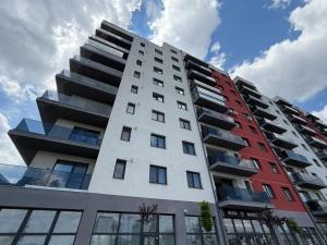 a tall apartment building with red and white at Apartament Luna in Şelimbăr