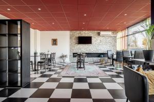 a lobby with a checkered floor and tables and chairs at First Hotel Halmstad East in Halmstad