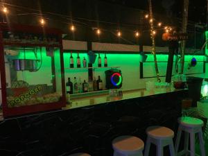 a green bar with stools and bottles of alcohol at Panama Experience Hostal in Panama City