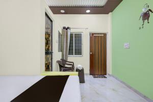 a room with a hallway with a chair and a door at HOTEL O GUMTHI in Māharjhari