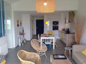 a living room and kitchen with a table and chairs at Côte et Dune in Biscarrosse-Plage