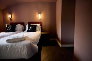 a hotel room with two beds with towels on them at Fuchsia Cottage - Accessible Comfort in Wilton