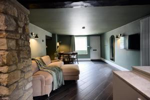 a living room with two chairs and a stone wall at Fuchsia Cottage - Accessible Comfort in Wilton +12 photos