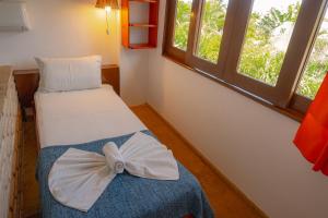 a room with two beds with a bow on it at Samba Pousada in Jericoacoara