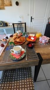 a table with food and a cup of coffee on it at L'écrin d'Ar Prajou in Plouénan