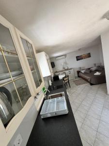 a kitchen and living room with a laptop on a counter at Studio Apartment Rose in Selca