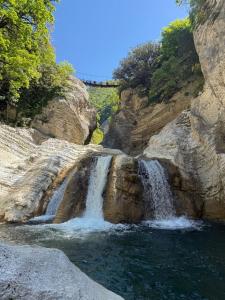 a waterfall on the side of a rocky cliff at Memo's GUEST house in Labova e Poshtme