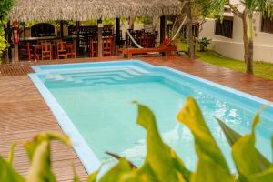 a blue swimming pool next to a patio with a restaurant at Samba Pousada in Jericoacoara +18 photos