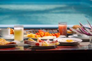 a table topped with plates of food and drinks at Samba Pousada in Jericoacoara