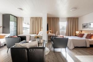 a hotel room with two beds and two chairs at First Hotel Halmstad East in Halmstad +75 photos