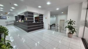 a lobby with a counter in a building at Hotel Manoá Poa - Ambiente acolhedor e humanizado, seu refúgio estratégico no centro de Poa, próx a UFRGS, rodoviária e a Santa Casa in Porto Alegre