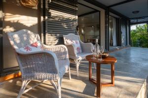 a group of chairs and a table on a porch at Blue Zebra - Le Jardin d'Antoinette in Rivière Noire