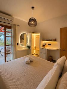 a bedroom with a large bed and a kitchen at Ligaries in Kini