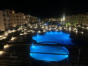 a pool with blue lights in a parking lot at night at Sharm Sea View - Sunny Beach in Sharm El Sheikh