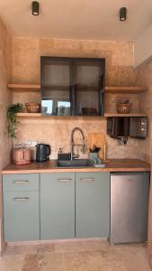 a kitchen with white cabinets and a sink at Olea Village in Potos