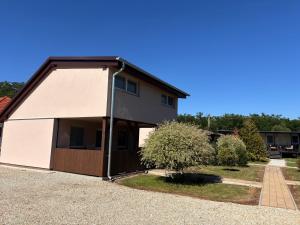 a house with a large garage in a driveway at Kerka Szállás in Kerkabarabás