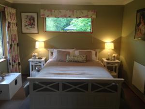 Newlands Bed and Breakfast في West Melton: غرفة نوم بسرير وطاولتين ونافذة