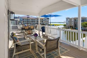 a porch with a table and chairs and an umbrella at 47 Oyster Bay Dr, Fenwick Island in Fenwick Island +42 photos