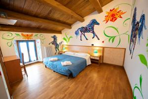 a bedroom with a bed and a mural of horses on the wall at Agriturismo Campo Rosso in Civitella di Romagna +73 photos