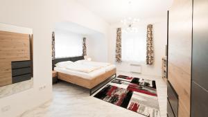 a bedroom with a bed and a rug at Strandhotel Orchidee in Sankt Kanzian +49 photos