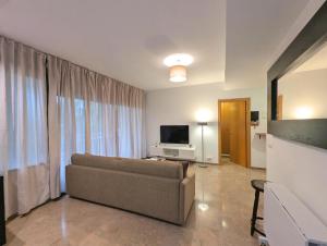 a living room with a couch and a television at Relax en Lloret con Gym y Piscina by Host&Joy in Lloret de Mar
