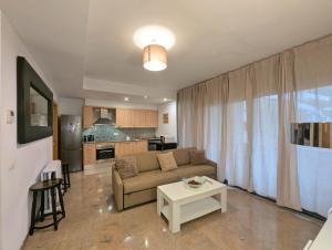 a living room with a couch and a table at Relax en Lloret con Gym y Piscina by Host&Joy in Lloret de Mar +17 photos