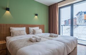 a bedroom with a large bed with towels on it at New Gudauri Twins Horizon in Gudauri