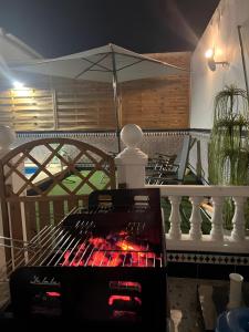 a grill on a balcony with an umbrella at Villa Gení in La Victoria
