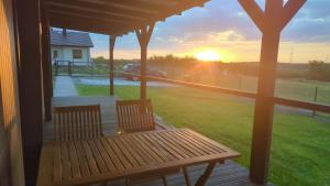 a bench on a porch with the sunset in the background at Dom nad wąwozem in Sandomierz