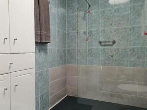 a bathroom with a shower with blue tile at Casa Kiara in Costa Calma +44 photos