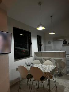 a kitchen with a table and chairs and a television at Tesla Apartman in Risan