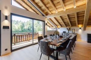 a dining room with a long table and chairs at Chalet des Granges 12 personnes Spa et cinéma in Morzine