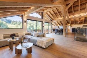 a living room with a couch and tables at Chalet des Granges 12 personnes Spa et cinéma in Morzine