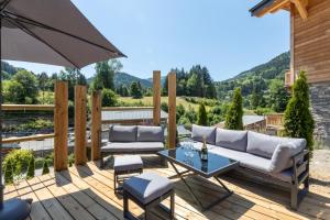a patio with a table and chairs and an umbrella at Chalet des Granges 12 personnes Spa et cinéma in Morzine +18 photos