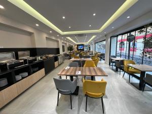 a restaurant with wooden tables and yellow chairs at Blanca Maris in Fuengirola